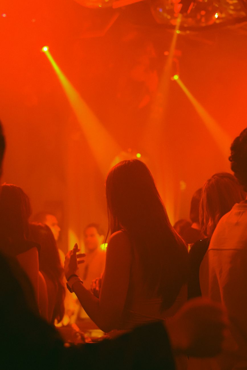 brunette woman in red light in nightclub