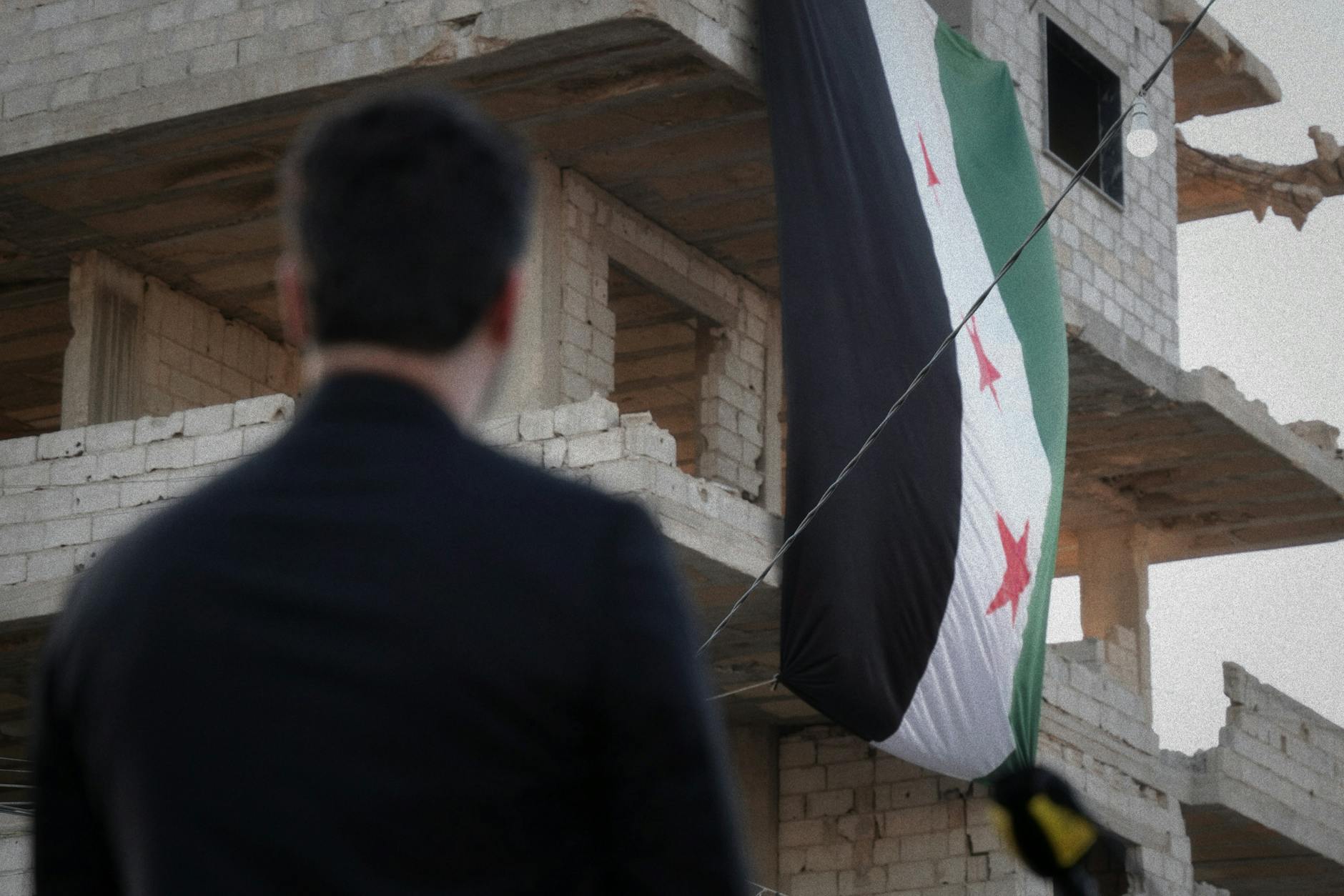 syrian flag on damaged building in damascus