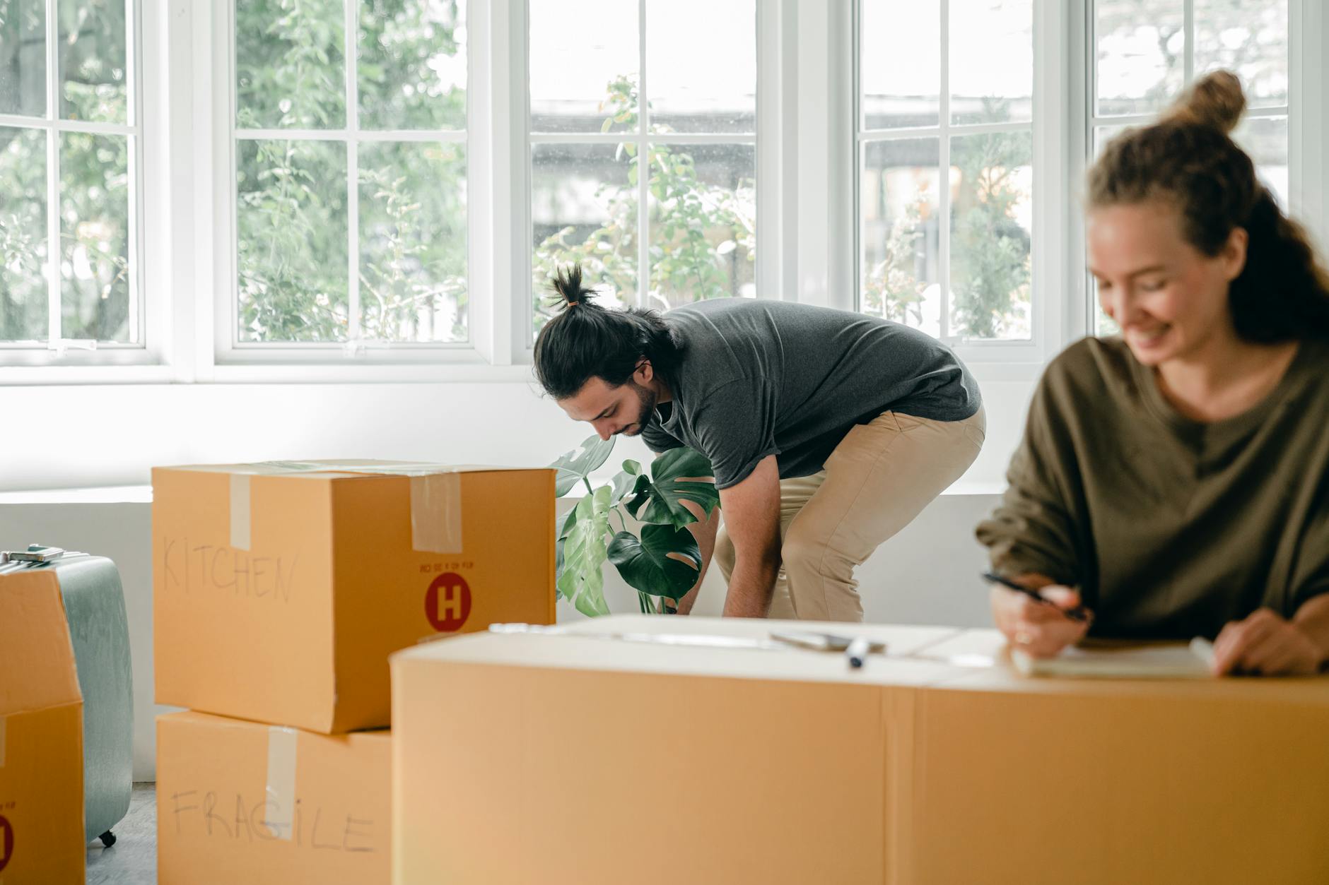 happy young couple among boxes at new home