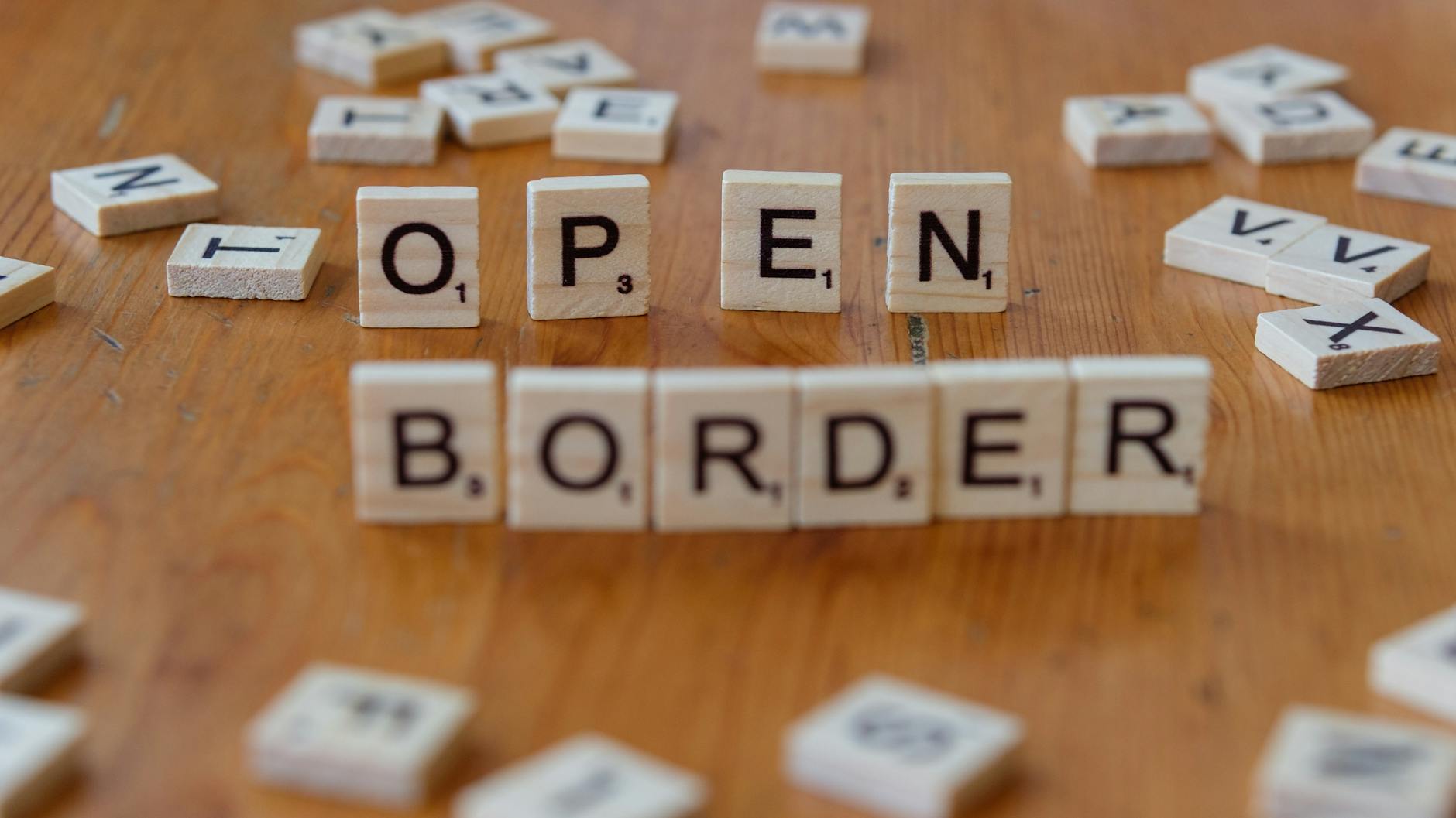 scrabble letter tiles spelling open border concept